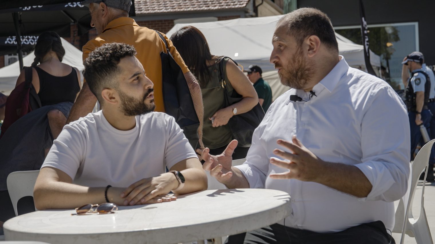Two men sitting at a table in the middle of a discussion