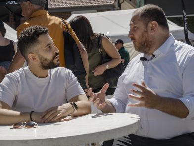 Two men sitting at a table in the middle of a discussion