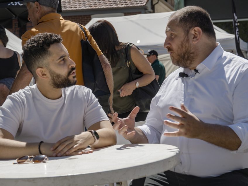Two men sitting at a table in the middle of a discussion